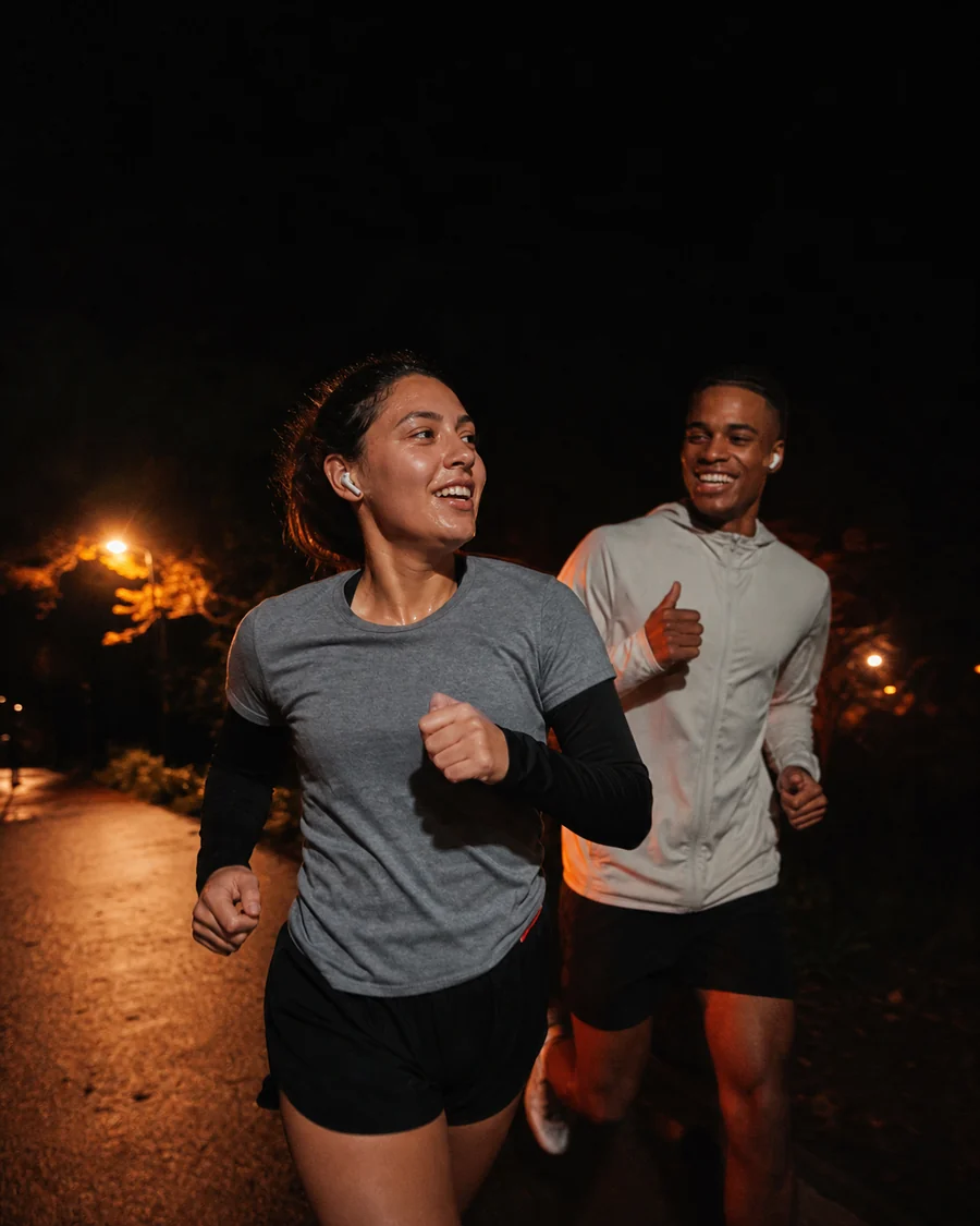 Two runners on a lit path at night